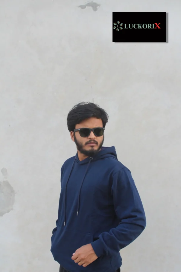 A man wearing a navy blue hoodie from LuckoriX, styled with sunglasses against a minimalist gray background.