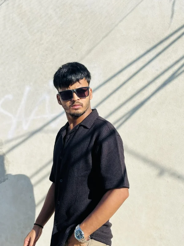 "Man wearing a black textured short sleeve button-up shirt by LuckoriX, styled with sunglasses and a watch"